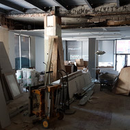 The original banking floor has been temporarily transformed into a staging area for construction materials and equipment.